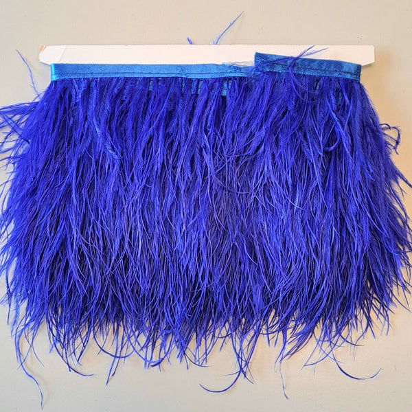 Super Luxurious Ostrich Feather trim, coloured and on co-ordinating coloured ribbon. Great for dressmaking, crafting, home decor and costume. A fashionable royal blue colour-way on a co-ordinating ribbon. Sold in metre increments