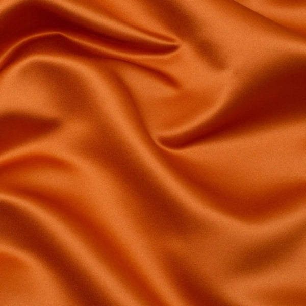 Duchess Satin fabric is a highly lustrous, smooth, very finely woven heavy non stretch satin. It has a very subtle sheen that is classic and elegant and very different in appearance to most satins which generally have a high gloss finish. This is the soft Burnt Orange. Sold in half meter lengths at Fabric Focus.