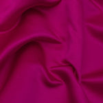 Duchess Satin fabric is a highly lustrous, smooth, very finely woven heavy non stretch satin. It has a very subtle sheen that is classic and elegant and very different in appearance to most satins which generally have a high gloss finish. This is the colourful Fuchsia. Sold in half meter lengths at Fabric Focus.