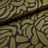 Gorgeous viscose twill of modern green pebble shapes on a black background available at Fabric Focus Edinburgh
