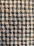 Close-up of a checkered fabric with blue, beige, and brown colors.