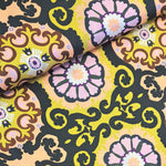 Polyester with chartreuse, black, pink and brown 'roundelles' with Moroccan inspiration. Available to buy in half metre increments at Fabric Focus.