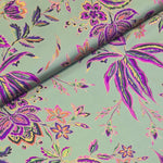 Polyester satin with a celadon green background with purple stylized floral pattern. Available to buy in half metre increments at Fabric Focus.