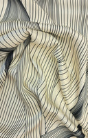 A striking print of multiple black lines on a cream background.  Sold in half metre increments at Fabric Focus Edinburgh.