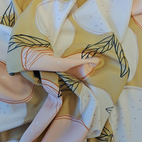 A stunning print of white and peach coloured apples with black/green leaves on a sand ochre background. Perfect for wrap dresses, wide legged trousers and blouses. Great for all summer designs including trousers and dresses. Sold in half metre increments.