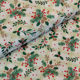 A close-up of patterned fabric with a Christmas holly and pine design over a pale green plaid background. The fabric is folded to show its texture and weight.
