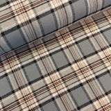 A close-up of plaid fabric with a gray base and intersecting stripes in beige, black, and thin red lines.