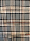 A close-up of a plaid fabric pattern with a gray base, cream stripes, and thin black and red lines.