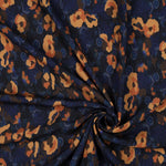 A beautiful print of amber flowers on a cobalt/navy background. Perfect for wrap dresses, wide legged trousers and blouses. Manufacturer recommends 30 degree wash but please allow for shrinkage and test a piece before hand.  Sold in half metre increments at Fabric Focus Edinburgh.