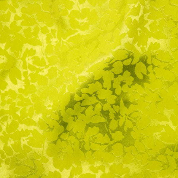 A beautiful soft polyester satin that has a subtle sateen sheen and a high gloss finish that makes up this floral jacquard. It has a high-end expensive look. Perfect for evening wear and day wear alike! This being the bright lime colourway.  Sold in half meter lengths at Fabric Focus.