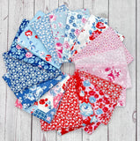 Collection of floral fabric samples in various colors on a wooden surface