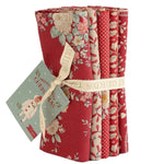 Set of fabric rolls with floral patterns and a Christmas-themed card on a white background