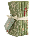 Set of green fabric rolls with various patterns and a card on a white background