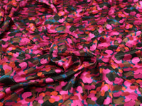 Gorgeous viscose satin print of abstract shapes in shades of pink, orange, black on a teal 
 background from Fabric Godmother and available at Fabric Focus.