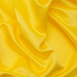 Duchess Satin fabric is a highly lustrous, smooth, very finely woven heavy non stretch satin. It has a very subtle sheen that is classic and elegant and very different in appearance to most satins which generally have a high gloss finish. This is the bright yellow Daffodil. Sold in half meter lengths at Fabric Focus.