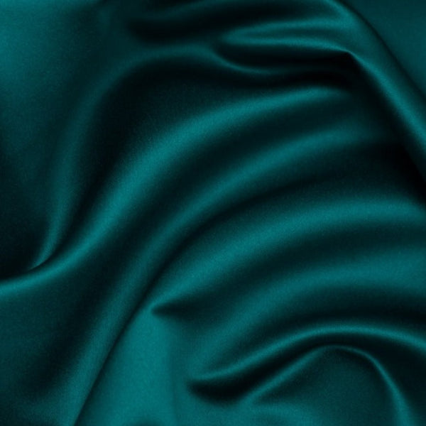 Duchess Satin fabric is a highly lustrous, smooth, very finely woven heavy non stretch satin. It has a very subtle sheen that is classic and elegant and very different in appearance to most satins which generally have a high gloss finish. This is the rich Teal. Sold in half meter lengths at Fabric Focus.