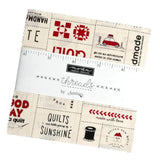 Fabric with printed designs and a ruler on top, featuring text and symbols.