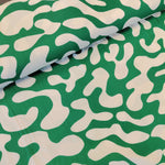 viscose twill with cream shapes on an emerald green backfround