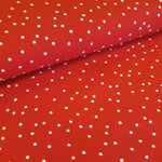 A scarlet red viscose challis with small white spots, Available to buy in store and online at Fabric Focus Edinburgh.