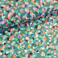 Gorgeous viscose print of multi-coloured confetti spots on a emerald green background. Wonderful for dressmaking, tops, skirts and wide leg trousers. Available to buy online at fabric Focus in half metre increments.